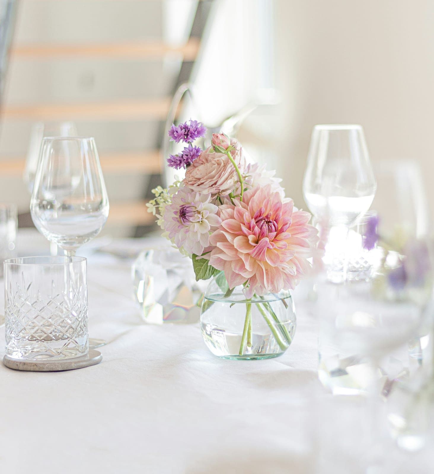 Table dressée en cristal et fleurs pour une réception privée dans un appartement parisien